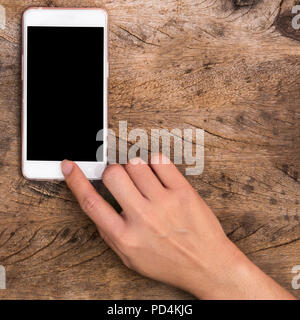 hand touching home button on wooden table Stock Photo