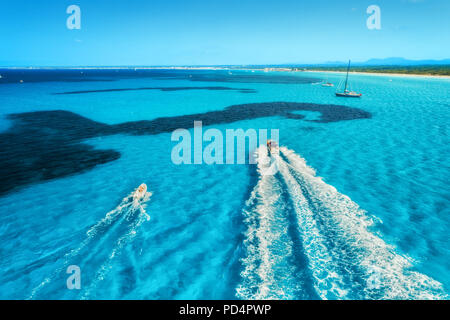 Speed motorboats on the seashore in Mallorca, Spain. Aerial view of floating boat on the transparent blue sea at sunny bright day. Summer travel. Top  Stock Photo