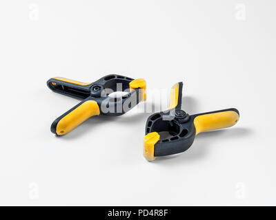 Metallic black with plastic yellow inserts construction clip lies on a white background Stock Photo