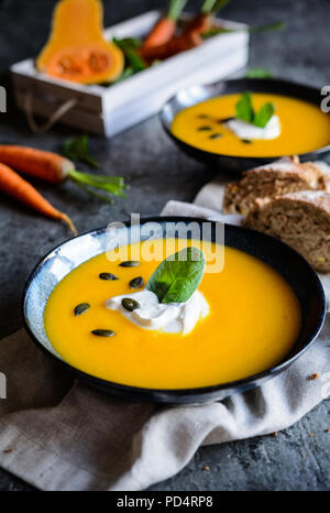 Traditional pumpkin and carrot soup with sour cream Stock Photo
