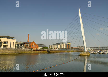 Wide angle view of the Sail Bridge, a footbridge of the River Tawe. It is part of the Swansea SA1 development which incorporates the marina. Stock Photo