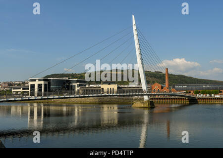 Wide angle view of the Sail Bridge, a footbridge of the River Tawe. It is part of the Swansea SA1 development which incorporates the marina. Stock Photo