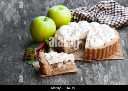 Tasty  meringue pie with rhubarb and apple on wooden table Stock Photo