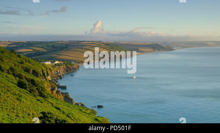 Sunrise over Start Bay from near the light house looking along the coast towards Beesands and Slapton Sands with the remains of the 'lost village' of  Stock Photo