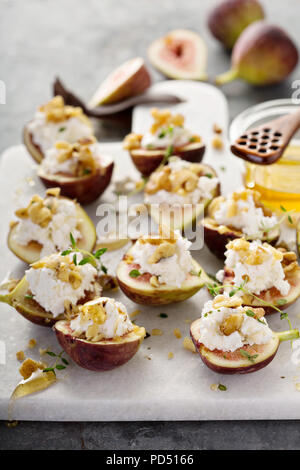 Fall appetizer, fresh figs stuffed with ricotta and pine nuts with honey and thyme Stock Photo