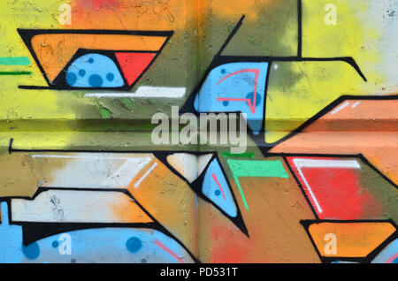 Multicolored graffiti on an old concrete wall. A beautiful form of vandalism in urban conditions. Different lines and shapes, painted with cans of pai Stock Photo