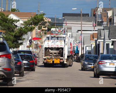 Garbage truck making rounds along a narrow seashore street in New Jersey showing how crowded the area is during the summer. Stock Photo