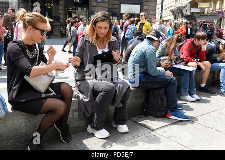 Young women smoking cigarettes in city centre street Vienna, Austria Stock Photo