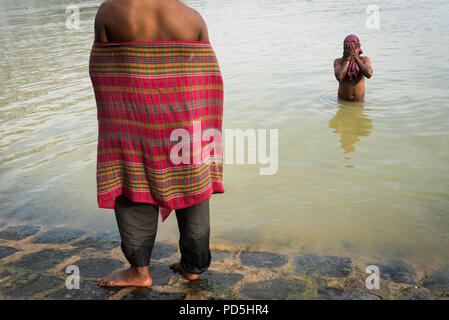 Two men bathing by the river in Kolkata, India Stock Photo