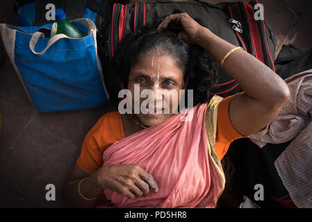 A portrait of a woman resting on the road while taking a break from her travels in Kolkata, India Stock Photo