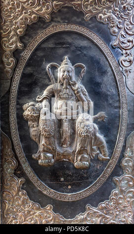 Metal embossed art with a bearded man as a portrait in a type of fancy golden frame sitting on a pet dragon. Stock Photo