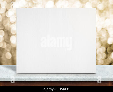Blank white paper poster on white marble table top and sparkling gold bokeh light,Mock up to display or montage of your content,holiday background Stock Photo