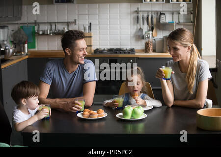 Happy family and kids having breakfast sitting at kitchen table Stock Photo