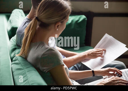 Couple filling online form using laptop checking information wit Stock Photo