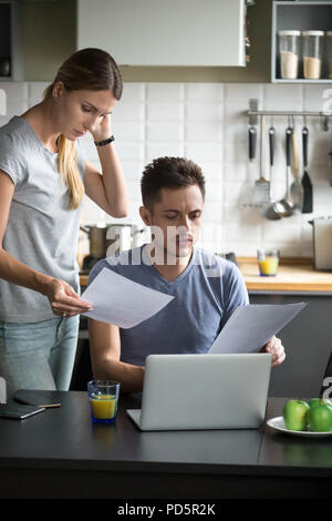 Confused young couple worried checking domestic bills having fin Stock Photo