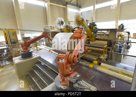 Industrial robot in a paper mill - automation in a modern plant - recycling of waste paper Stock Photo