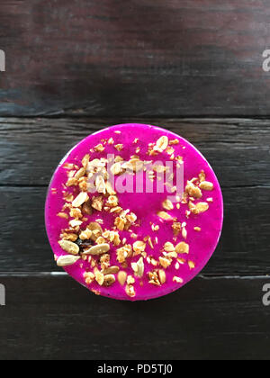 Glass with a pink energy fruit cocktail smoothie dragonfruit on a wooden table, top view Stock Photo