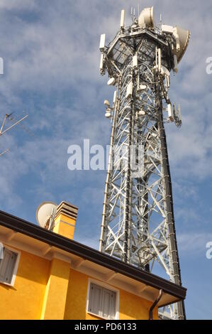 Telecommunication tower with antennas over the top of a building Stock Photo