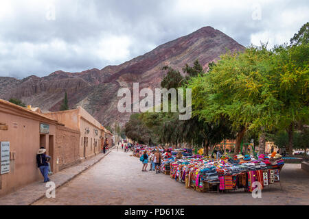 Street of Purmamarca town with traditional handicraft clothing stalls  - Purmamarca, Jujuy, Argentina Stock Photo