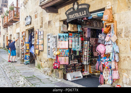 Santillana, Spain - 8th July 2018: Tourists looking at souvenirs outside a shop. Many tourists visit the town. Stock Photo