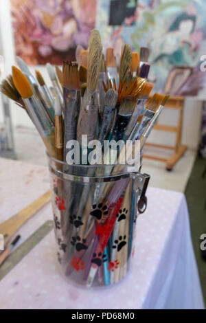 Paint brushes and art supplies in an art studio. Stock Photo