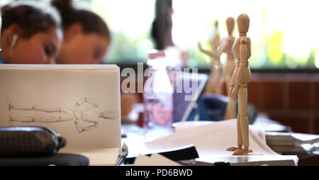 Visual Art high school students working from wooden mannequins practicing drawing human fugure and correct proportion. Artists being creative the art  Stock Photo