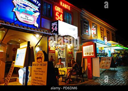 Tourists relaxing at a restaurant in the old town at night, Albufeira, Portugal, Europe. Stock Photo