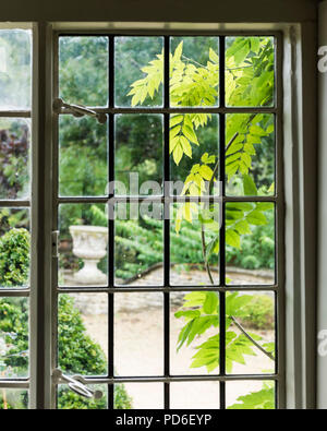 View through leaded glass window to back garden. Stock Photo