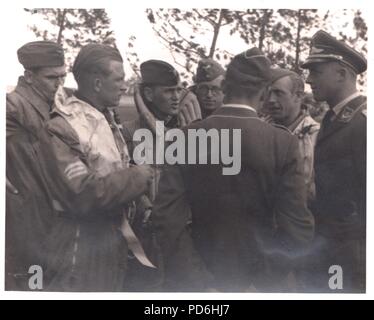 Image from the photo album of Oberleutnant Oscar Müller of  Kampfgeschwader 1: Oberleutnant Friedrich Clodius (second from left) in conversation with his crew and officers of 5./KG 1 in the summer of 1941. Leutnant Oscar Müller is in the centre with his back to the camera. Clodius was the Staffelkapitän of 5./KG 1 during the summer of 1941 and until he was posted missing on 8th November 1941. Stock Photo