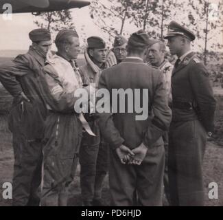 Image from the photo album of Oberleutnant Oscar Müller of  Kampfgeschwader 1: Oberleutnant Friedrich Clodius (second from left) in conversation with his crew and officers of 5./KG 1 in the summer of 1941. Clodius was the Staffelkapitän of 5./KG 1 during the summer of 1941 and until he was posted missing on 8th November 1941. Stock Photo