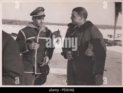 Image from the photo album of Oberleutnant Oscar Müller of  Kampfgeschwader 1: Oberleutnant Hans Sumpf (on right) at Dno Airfield in Russia in 1942. Sumpf was Staffelkapitän of 5./KG1 from 7th October 1941 until his death on 26th March 1942. He was posthumously awarded the Ritterkreuz (Knight's Cross of the Iron Cross) on 20th August 1942. Stock Photo