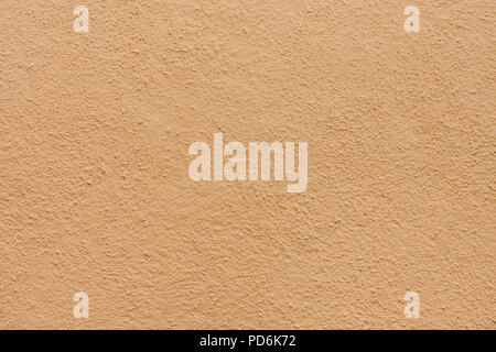 Stucco wall - Brown beige stucco textured wall background with natural light. Stock Photo