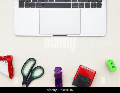 Paper-work tools of pencil, stapler, scissor, pencil sharpener and modern notebook on wooden table. Top views Stock Photo