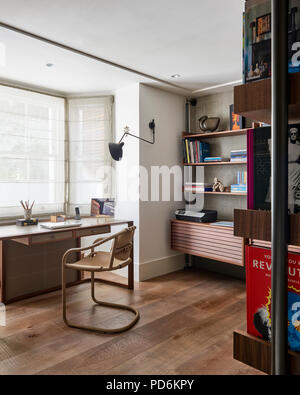 Deska nd chair in window with bookshelf Stock Photo