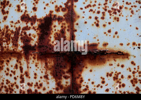 The metal surface rusted spots. Rysty corrosion. Corroded white metal background. Rusted white painted metal wall. Rusty metal background with streaks Stock Photo