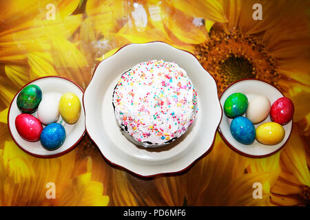 Easter cake with glace icing and easter eggs on table cloth background. Stock Photo