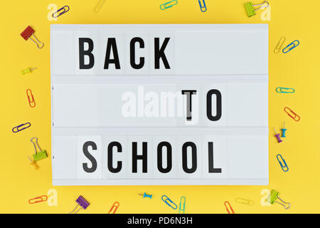 Lightbox with text BACK TO SCHOOL on yellow background with colorful stationery, flat lay template Stock Photo