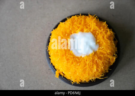 Top view Gold Egg Yolk Thread Cakes, or  'Cake Foi Tong' Thai cake isolated on brown cork table background with copy space Stock Photo