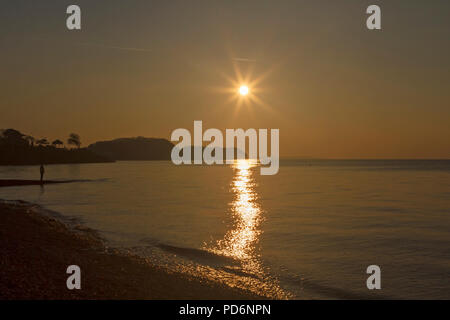 Streak of sunlight across the sea at sunset Stock Photo