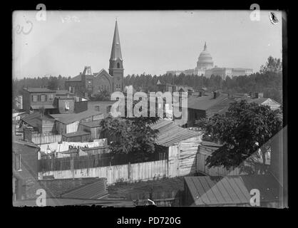 An overview of Wesley Zion Church in the midst of public housing, old wooden structures and trees; United States Capitol building on far right Stock Photo