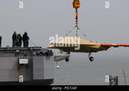 An X-47B is loaded onto flight deck of USS George H.W. Bush. (8720065823). Stock Photo