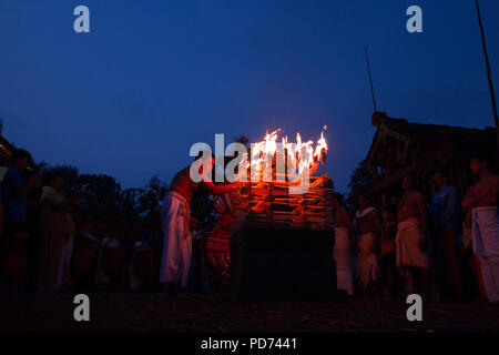 Early morning ritual related to Theyyam. Devotee lighting the lamp in traditional temple. Vishakandan Theyyam, Kaavu, Kerala. Stock Photo