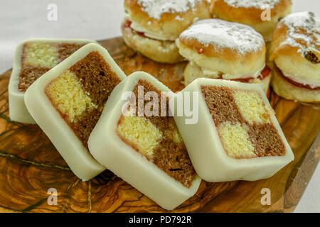 home baked battenberg cake and scones on wooden platter Stock Photo