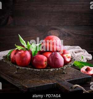 red ripe peaches nectarine in an iron plate,  close up Stock Photo