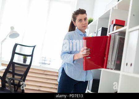 A young girl in the office takes out a folder with documents from the shelter. Stock Photo