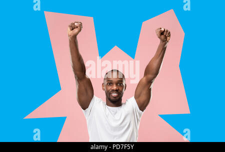 I won. Winning success happy man celebrating being a winner. Dynamic image of afro male model on green studio background. Victory, delight concept. Human facial emotions concept. Trendy colors Stock Photo