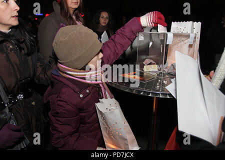 Little girl and other people donate money for charity and help for public use in Sofia, Bulgaria - dec 02, 2011. Charity donations concept. Stock Photo