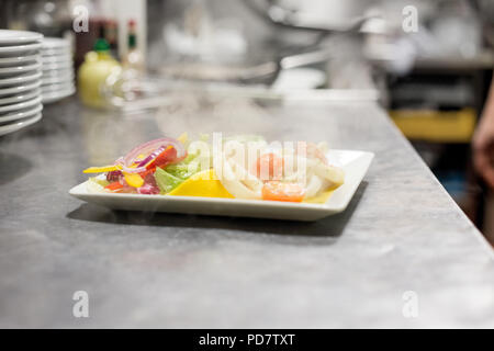 Chef preparing serving food in Italian restaurant kitchen. Stock Photo