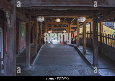 Inside the Japanese bridge with a look through to the street with a motorcycle. Hoi An Ancient Town Stock Photo