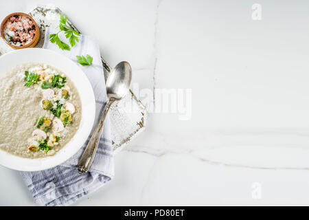 Mushroom champignon cream soup in a bowl with parsley, white marble background copy space Stock Photo